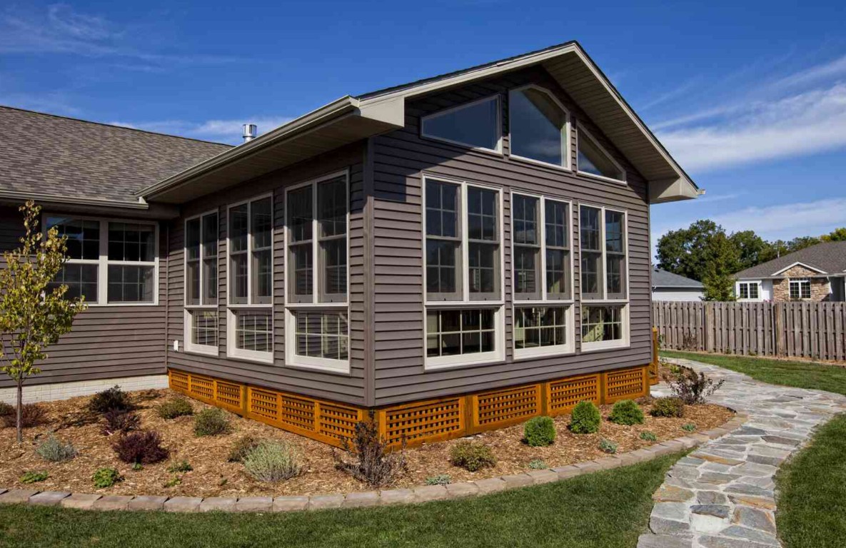 Gray-sided sunroom with white window frames and decorative lattice skirting in Thousand Oaks, CA